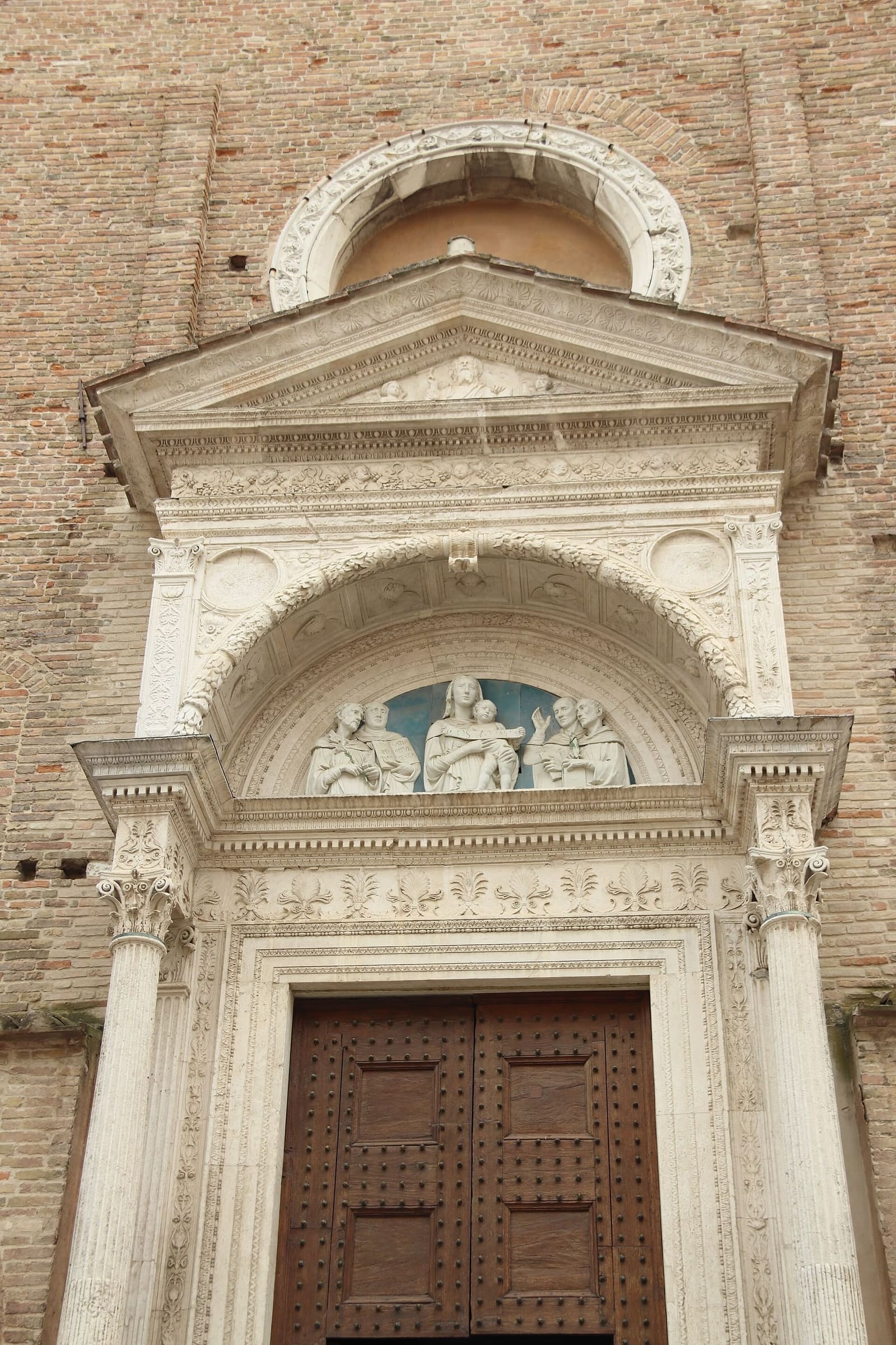 il portale rinascimentale di San Domenico, in marmo bianco sulla facciata di mattoni, con la lunetta sopra la porta