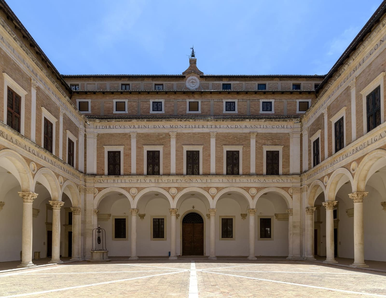 il cortile d'onore, con il portico di colonne, l'iscrizione che corre sopra gli archi e le finestre del piano nobile