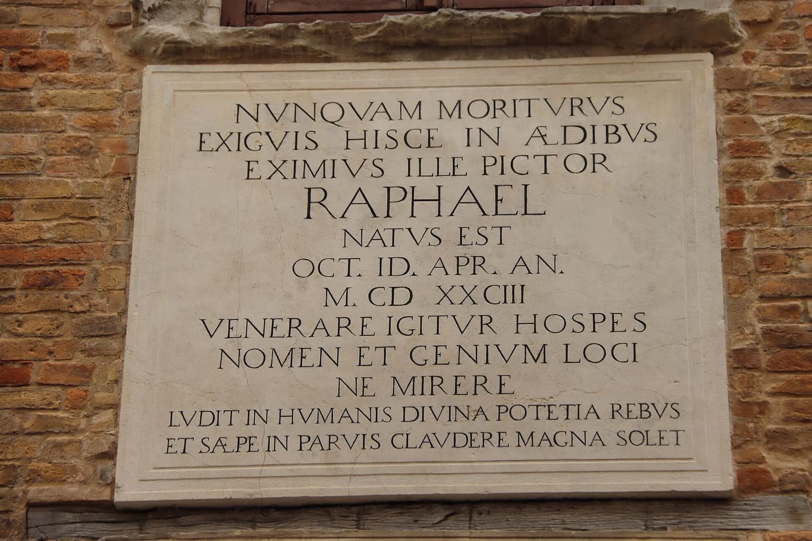 la lapide latina sul muro di mattoni della casa natale, che ricorda Raffaello nato qui nel 1483