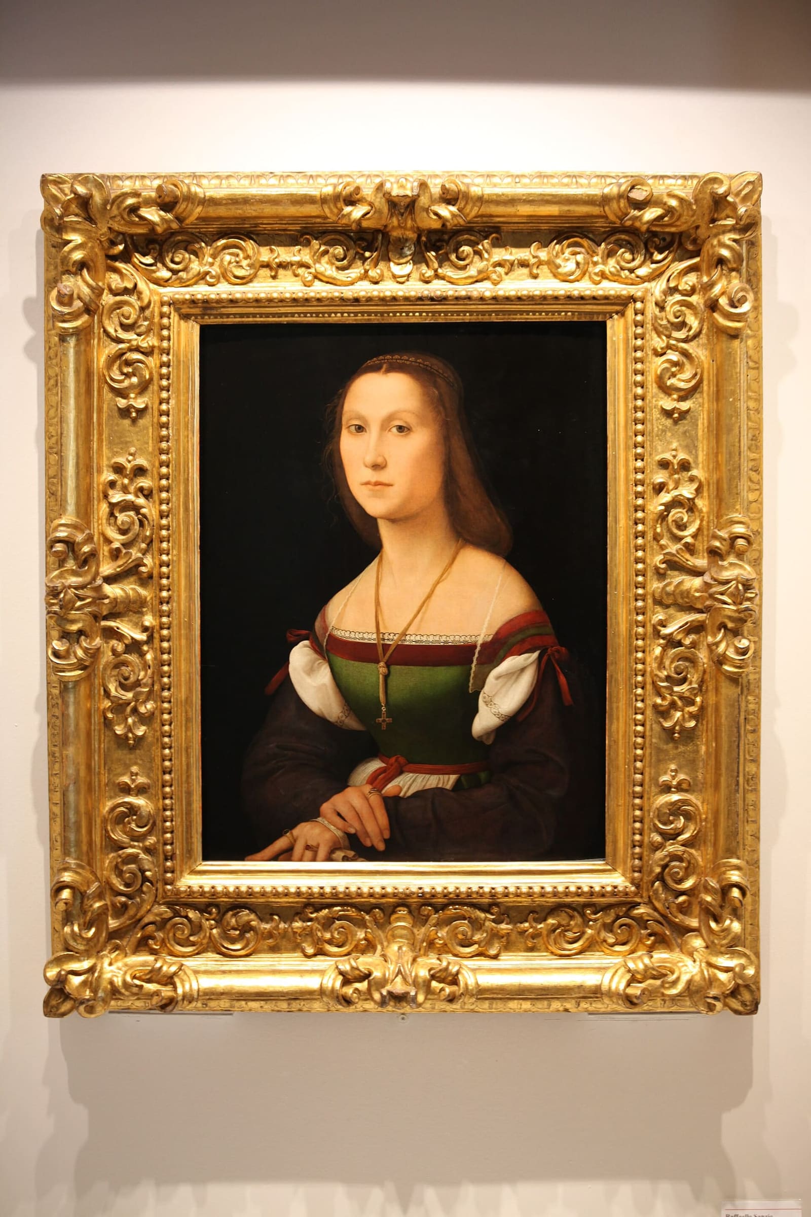 la Muta di Raffaello, il ritratto di donna in verde e rosso nella sua cornice dorata