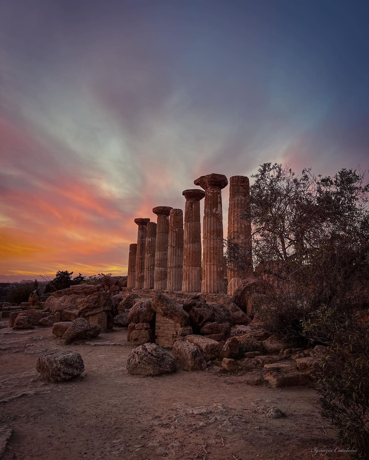 le otto colonne del tempio di Ercole sotto un cielo di tramonto, con i blocchi caduti ai piedi
