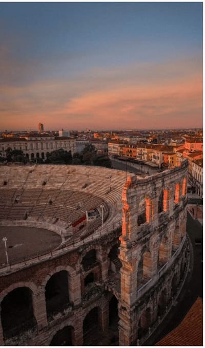 le gradinate dell'Arena viste dall'alto al tramonto, con i tetti della città dietro