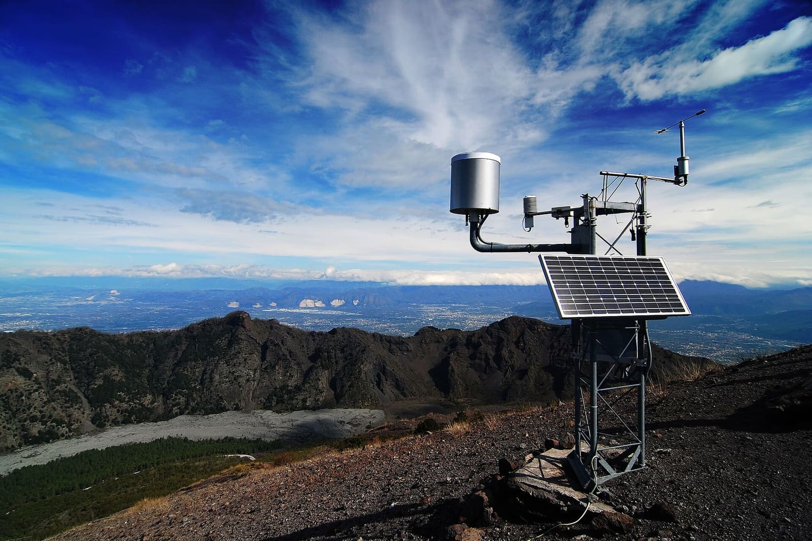 una stazione meteo sul bordo del cratere, con il Somma e la piana, a marzo