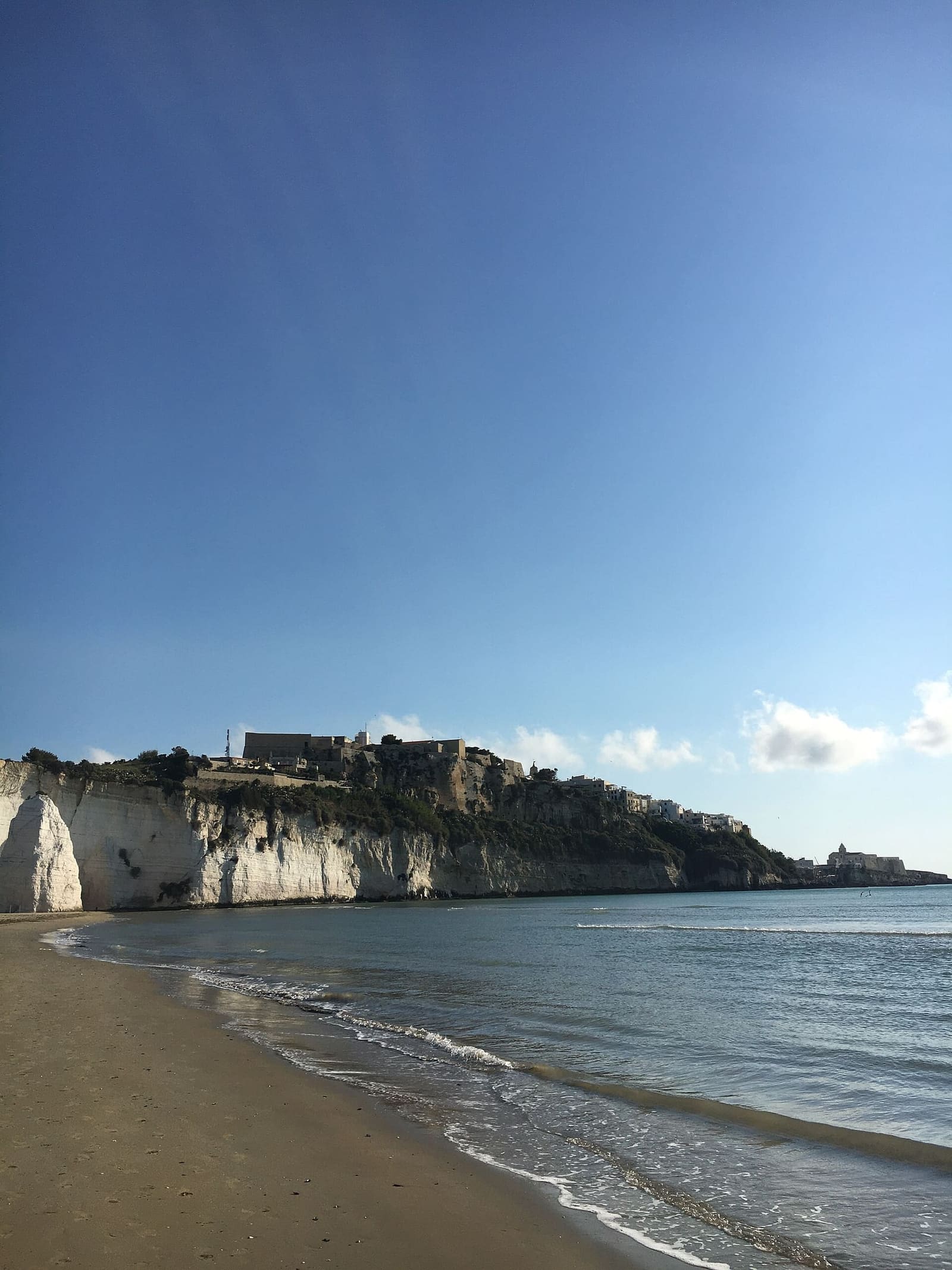 la spiaggia del Castello la mattina, con il Pizzomunno e il promontorio del paese