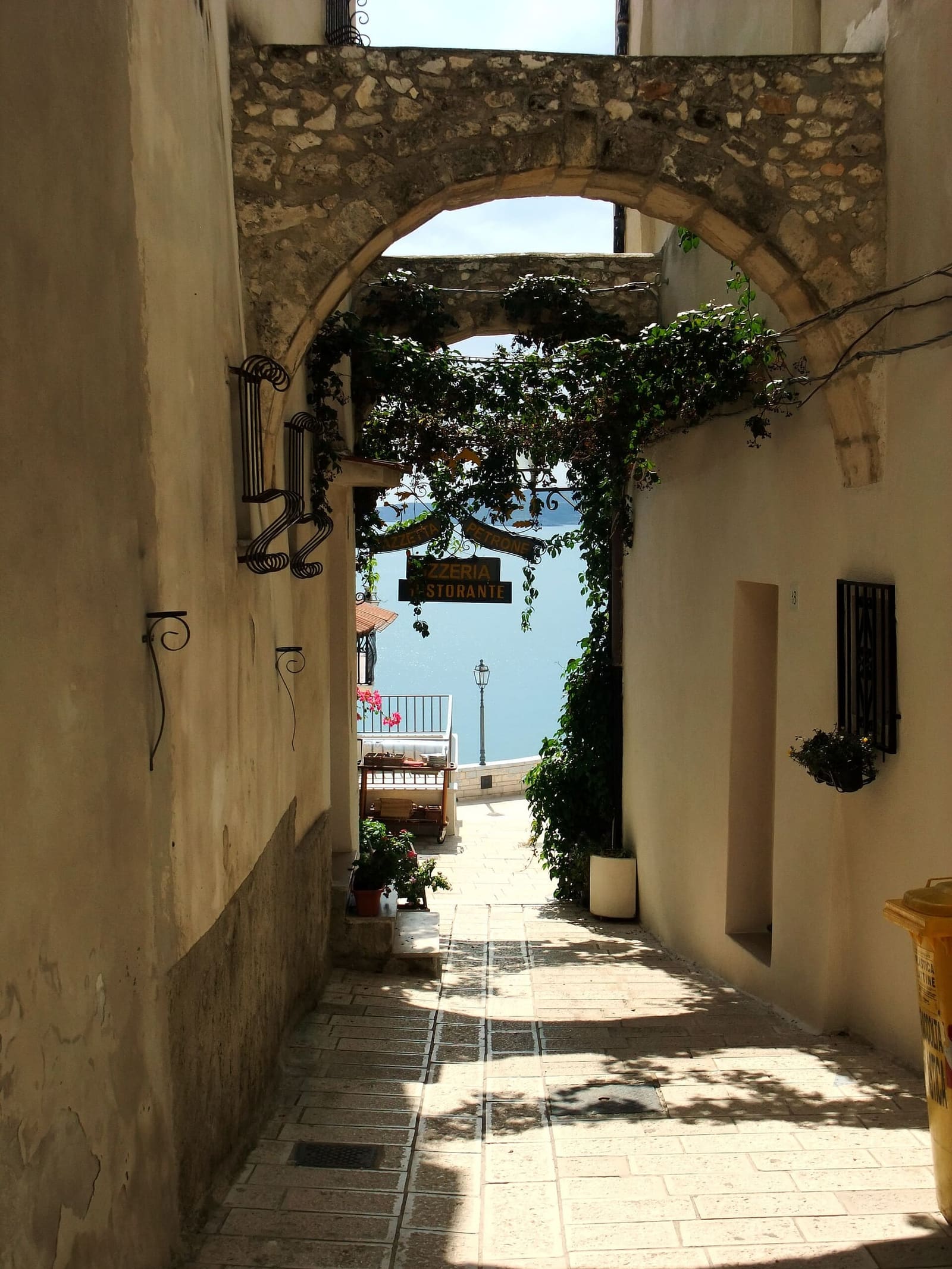 un vicolo del centro storico che scende verso il mare, sotto un arco